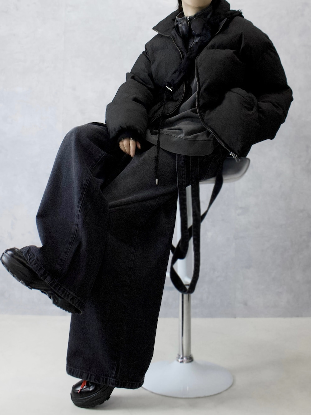 グレー系のデニムパンツ、ブラック系のスニーカー、ブラック系のダウンジャケット/コートを着用したメンズの冬コーディネートの2枚目の写真