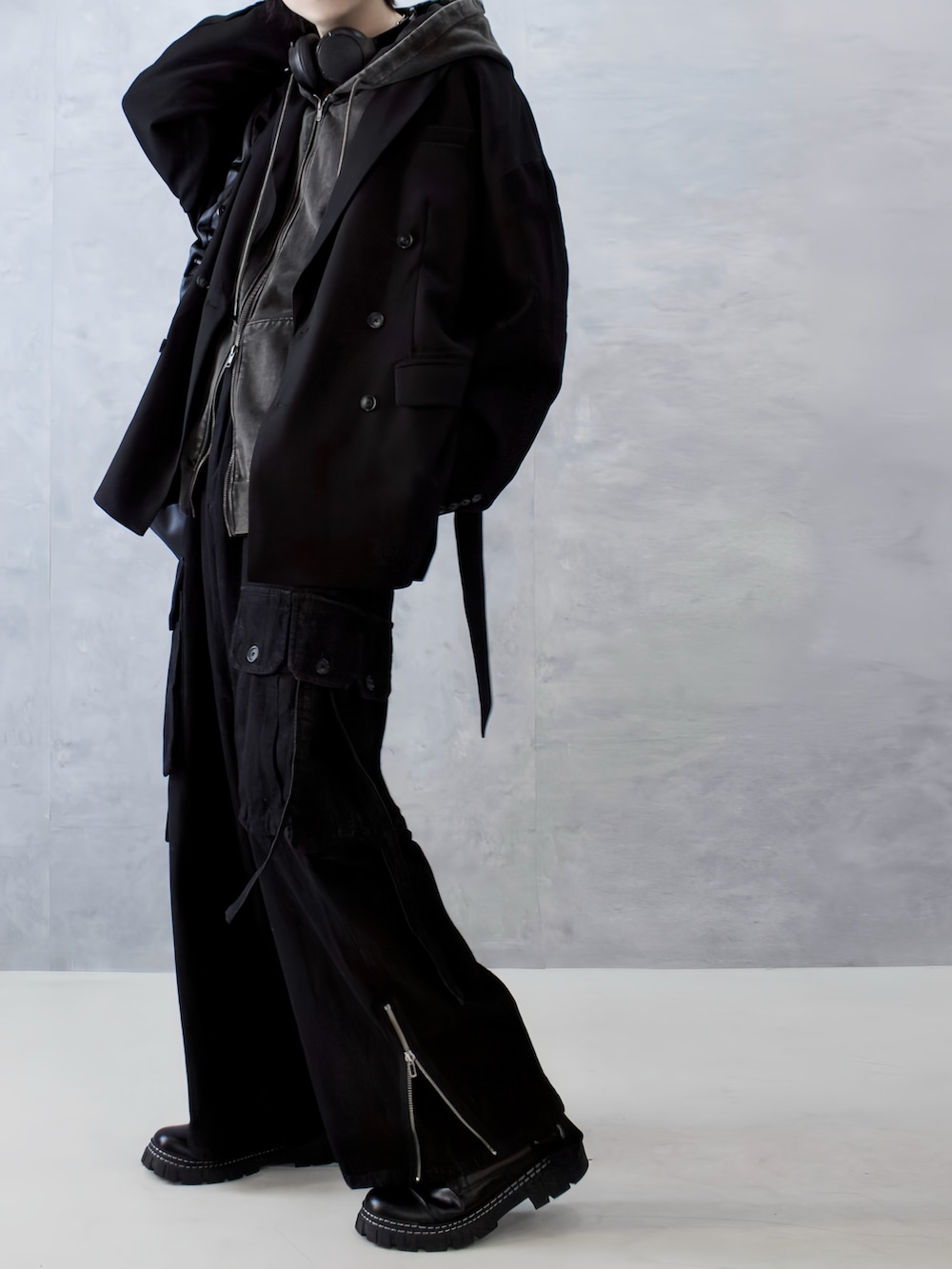 ブラック系のテーラードジャケット、ブラウン系のパーカー、ブラック系のカーゴパンツを着用したメンズの秋コーディネートの4枚目の写真