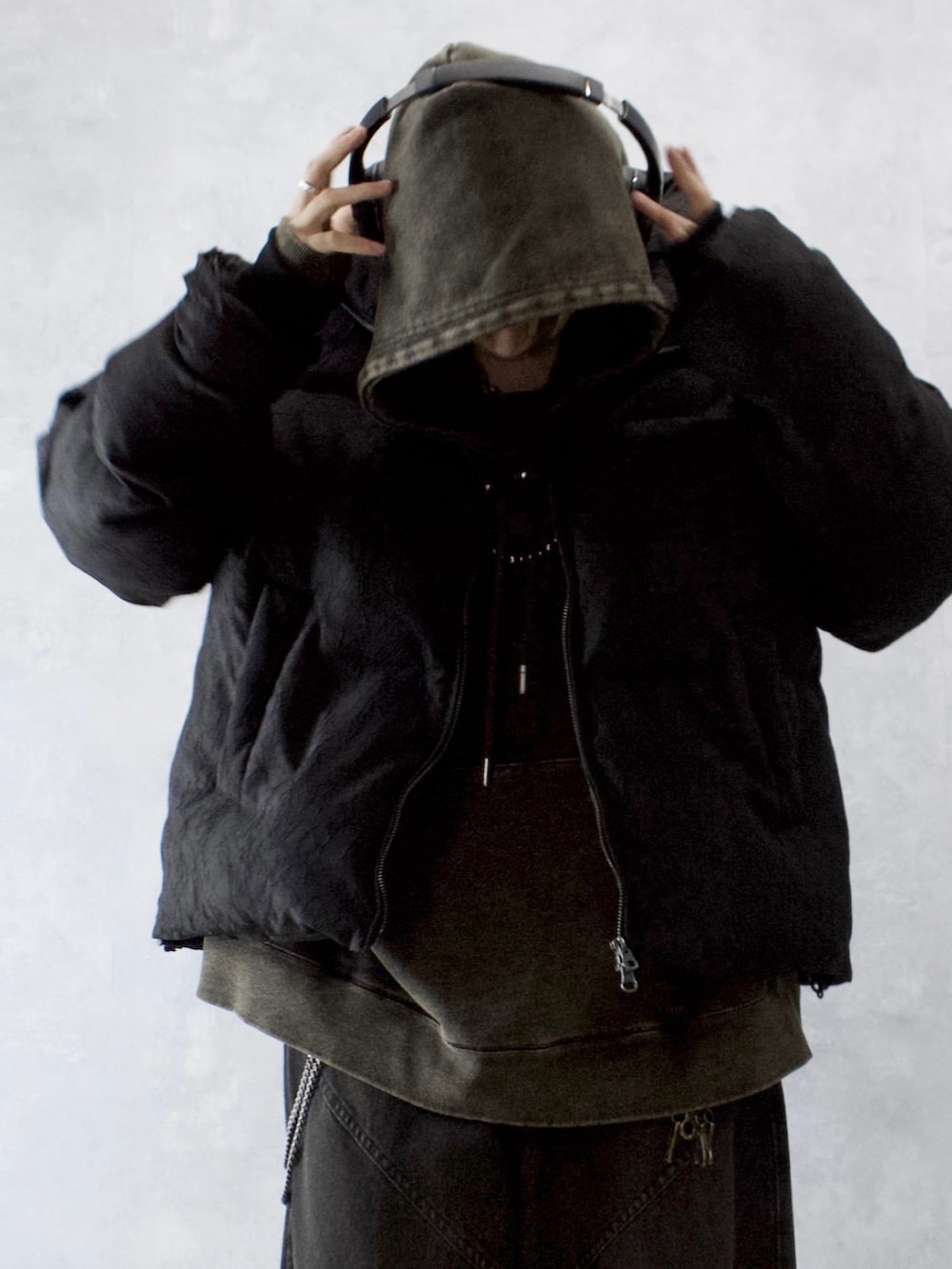 ブラック系のダウンジャケット/コート、ブラック系のパーカー、ブラック系のデニムパンツを着用したメンズの冬コーディネートの3枚目の写真