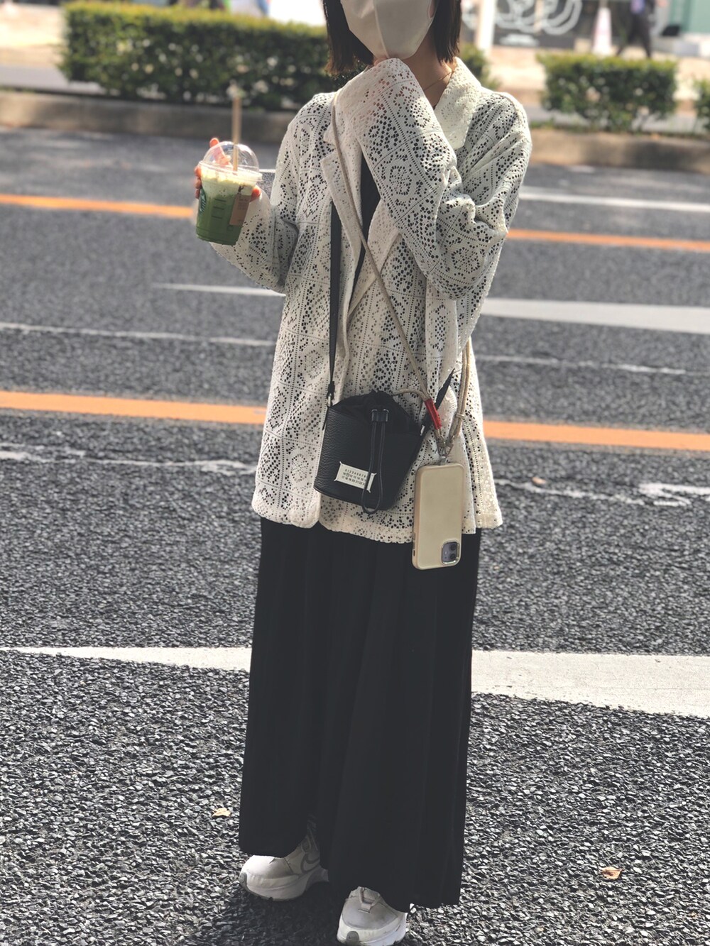 ホワイト系のスニーカー、ブラック系のワンピース、ホワイト系のジャケット/アウターを着用したレディースの春コーディネートの2枚目の写真