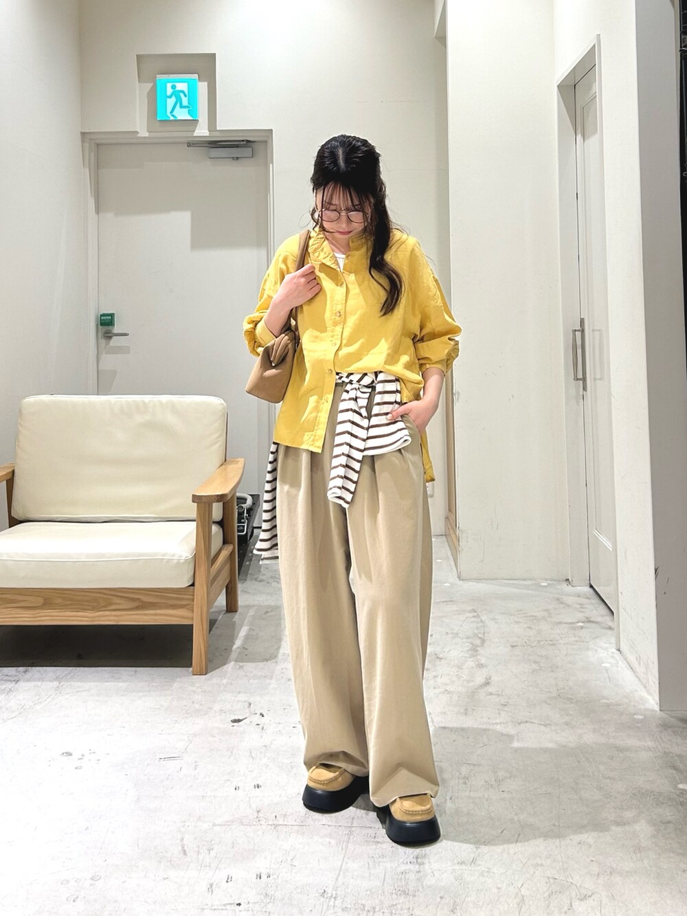 ホワイト系のタンクトップ、イエロー系のシャツ/ブラウス、ブラウン系のTシャツ/カットソーを着用したレディースの春コーディネートの2枚目の写真