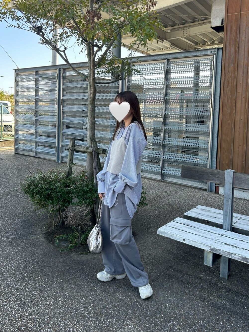 グレー系のスウェットパンツ、ゴールド系のショルダーバッグを着用したレディースの春コーディネートの3枚目の写真