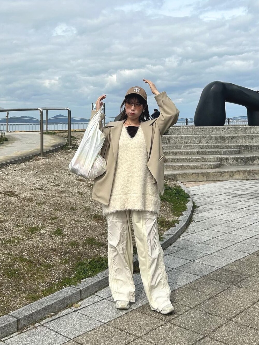 ホワイト系のベスト、ホワイト系のスウェットパンツ、ベージュ系のテーラードジャケットを着用したレディースの冬コーディネートの3枚目の写真