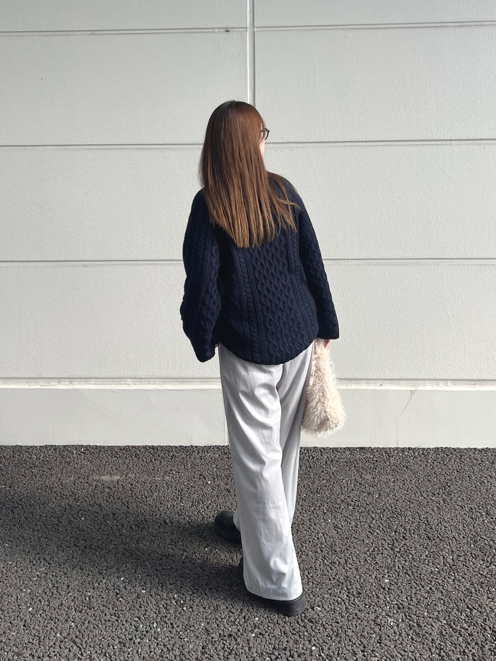 ブルー系のニット/セーター、ホワイト系のトートバッグ、グレー系のその他パンツを着用したレディースの冬コーディネートの3枚目の写真