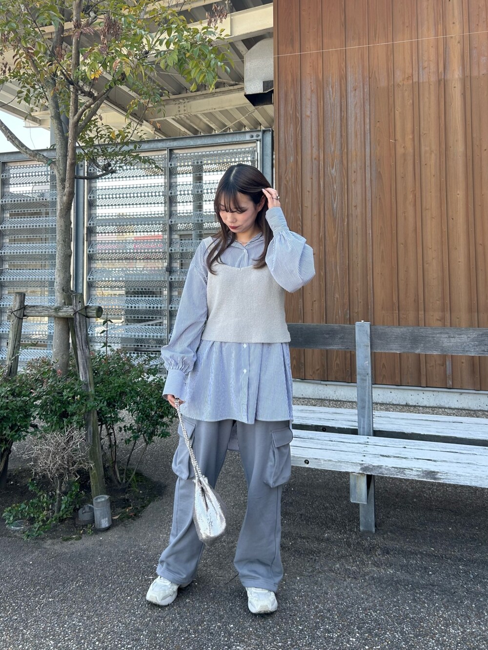 グレー系のスウェットパンツ、ゴールド系のショルダーバッグを着用したレディースの春コーディネートの4枚目の写真