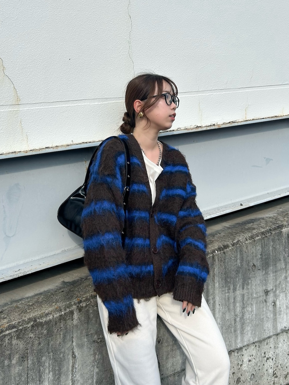 ブラウン系のカーディガン/ボレロ、ブラック系のトートバッグ、ホワイト系のTシャツ/カットソーを着用したレディースの冬コーディネートの2枚目の写真