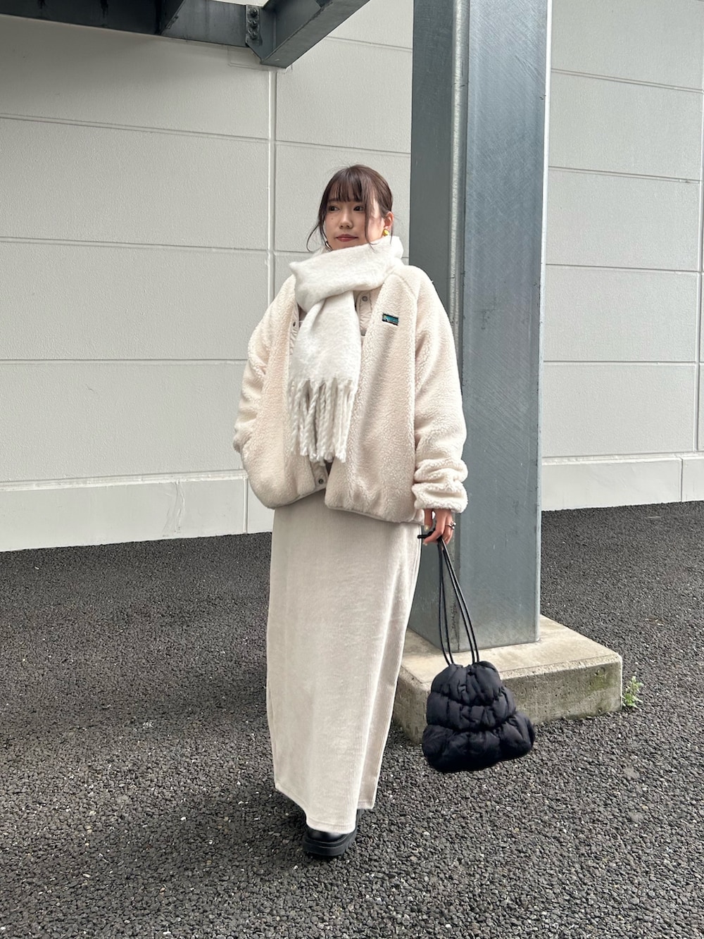 ホワイト系のブルゾン、ホワイト系のワンピース、ブラック系のショルダーバッグを着用したレディースの冬コーディネートの3枚目の写真