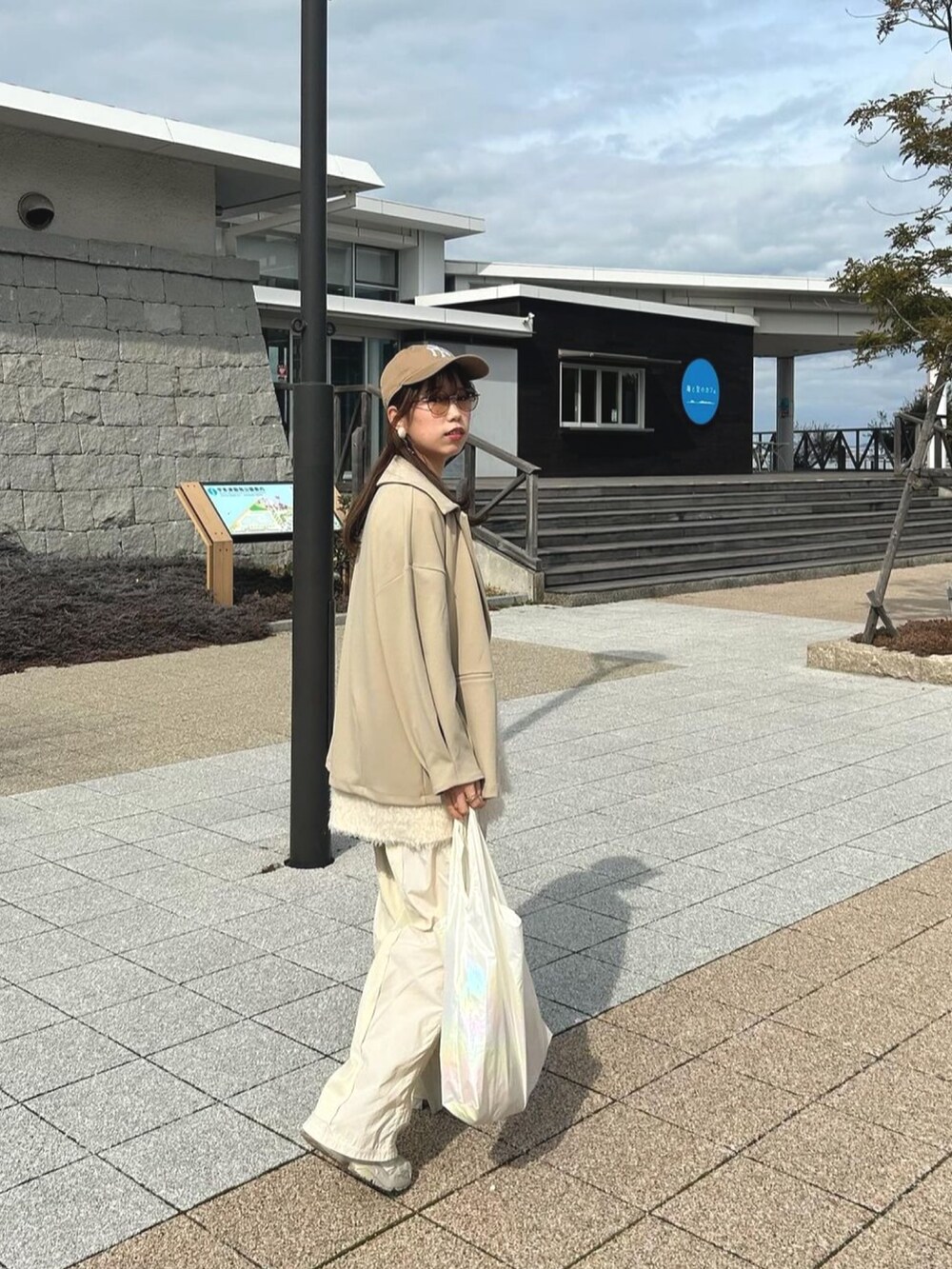 ホワイト系のベスト、ホワイト系のスウェットパンツ、ベージュ系のテーラードジャケットを着用したレディースの冬コーディネートの4枚目の写真