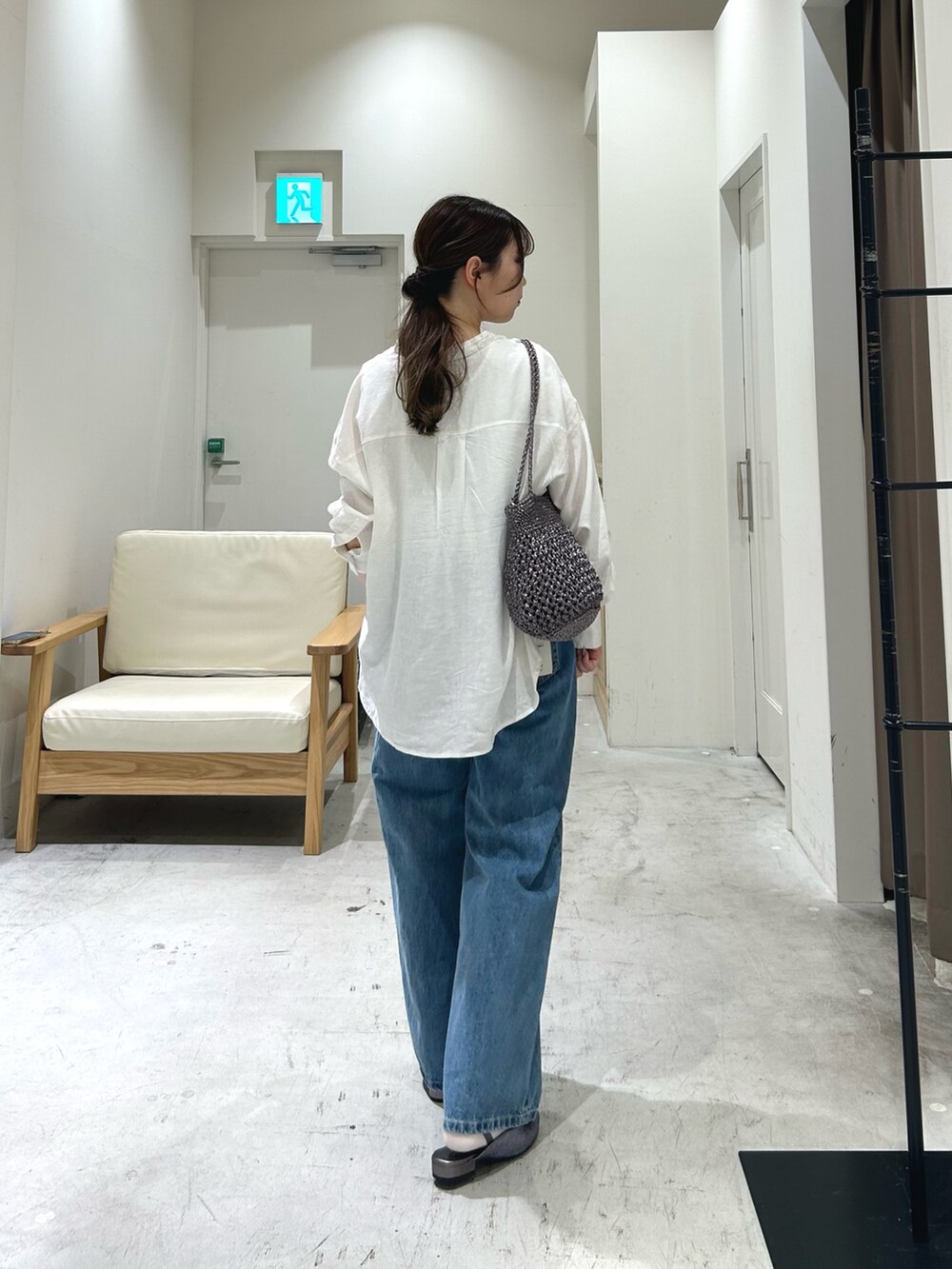 ブルー系のデニムパンツ、ホワイト系のシャツ/ブラウス、ホワイト系のタンクトップを着用したレディースの春コーディネートの2枚目の写真