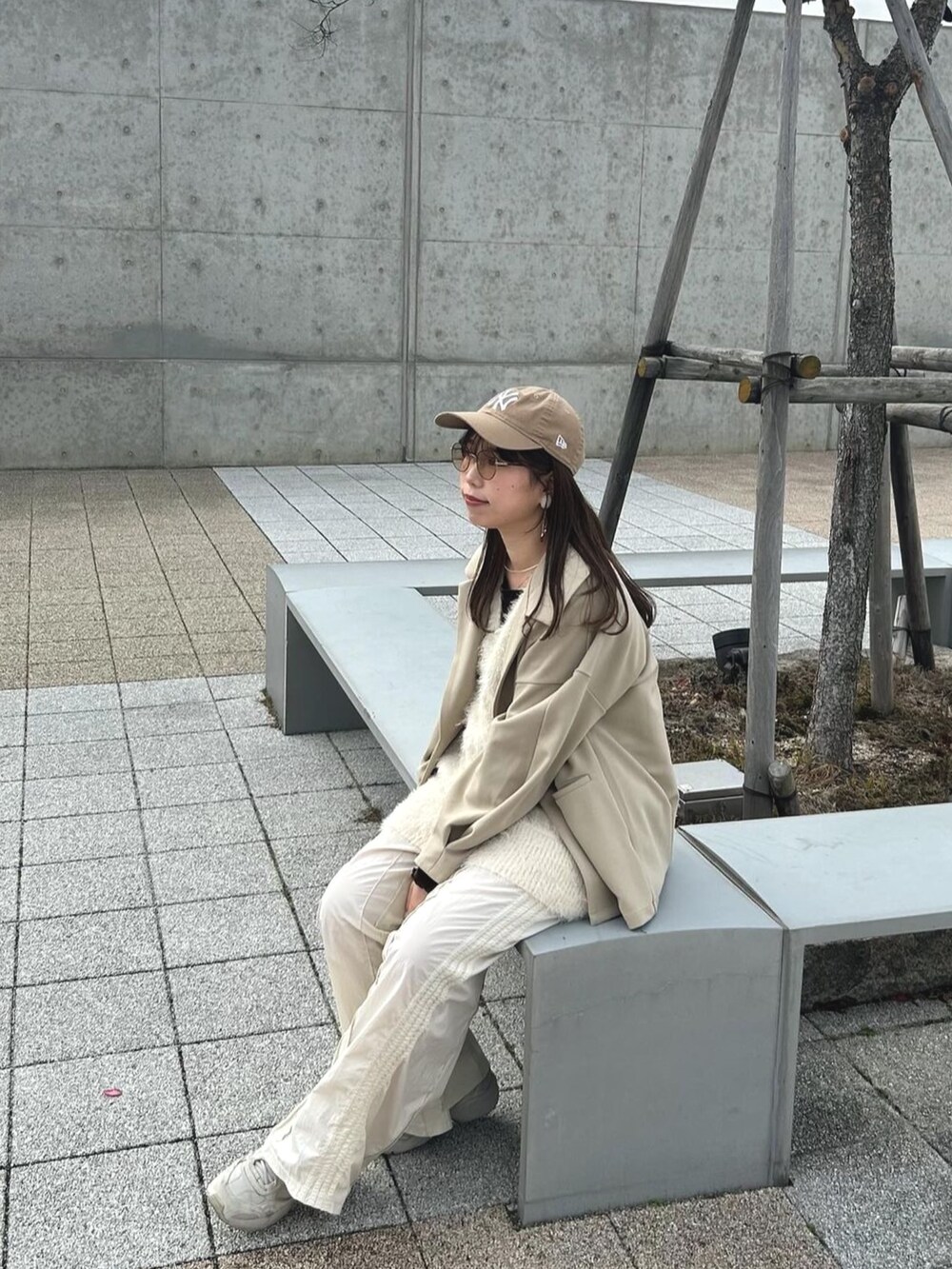 ホワイト系のベスト、ホワイト系のスウェットパンツ、ベージュ系のテーラードジャケットを着用したレディースの冬コーディネートの2枚目の写真