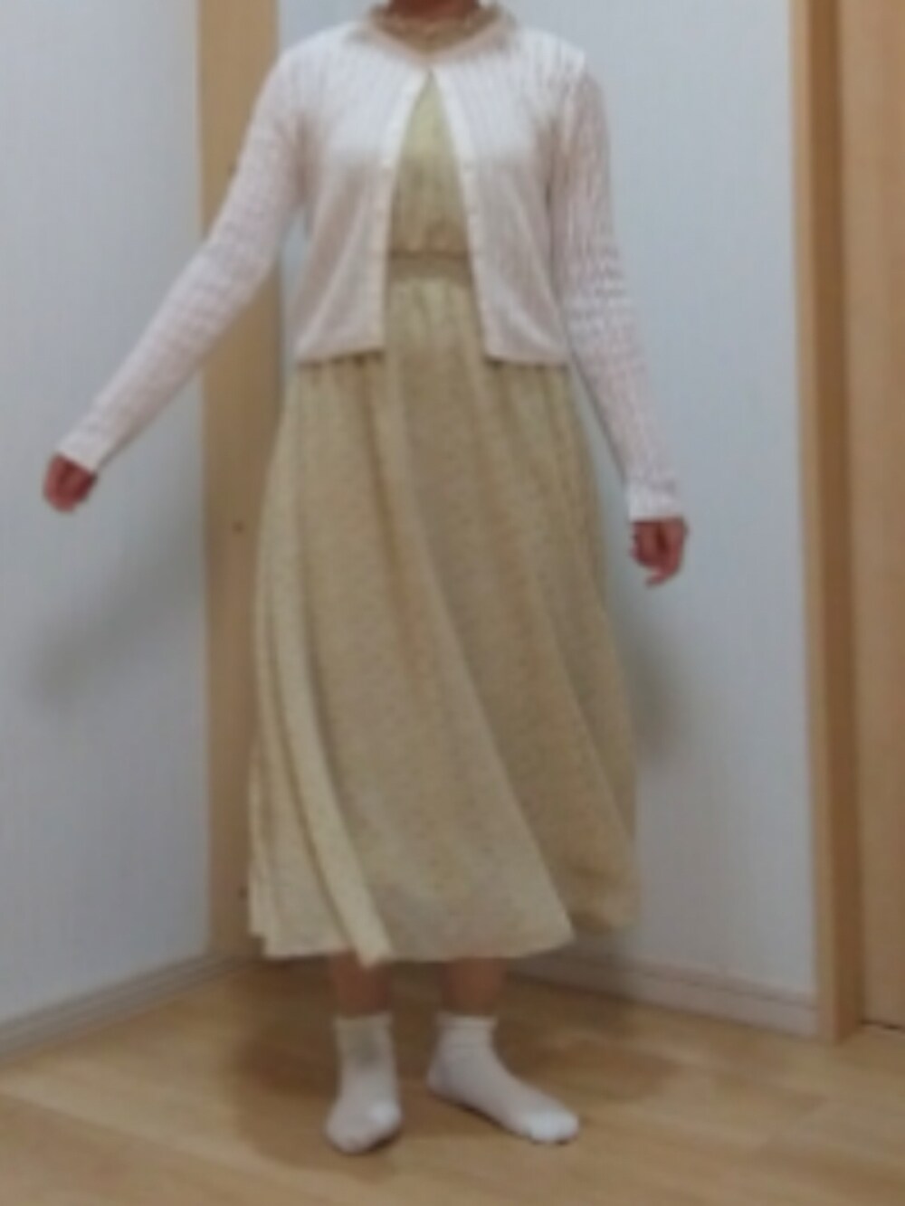 イエロー系のワンピース、ホワイト系のカーディガン/ボレロを着用したレディースの夏コーディネートの2枚目の写真