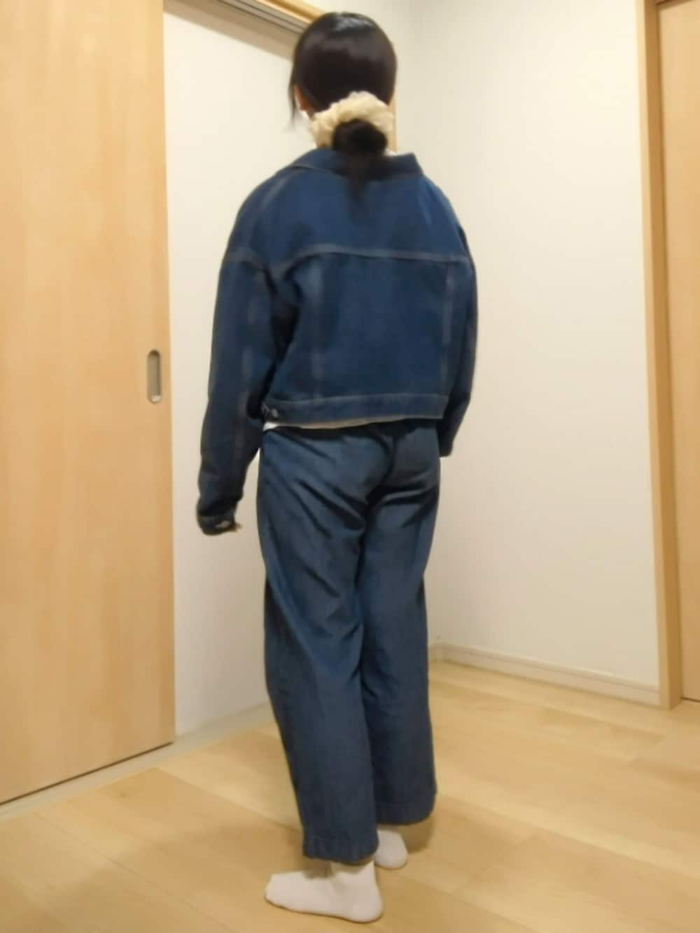 ブルー系のデニムパンツ、ブルー系のデニムジャケット、ホワイト系のその他トップスを着用したレディースの春コーディネートの2枚目の写真