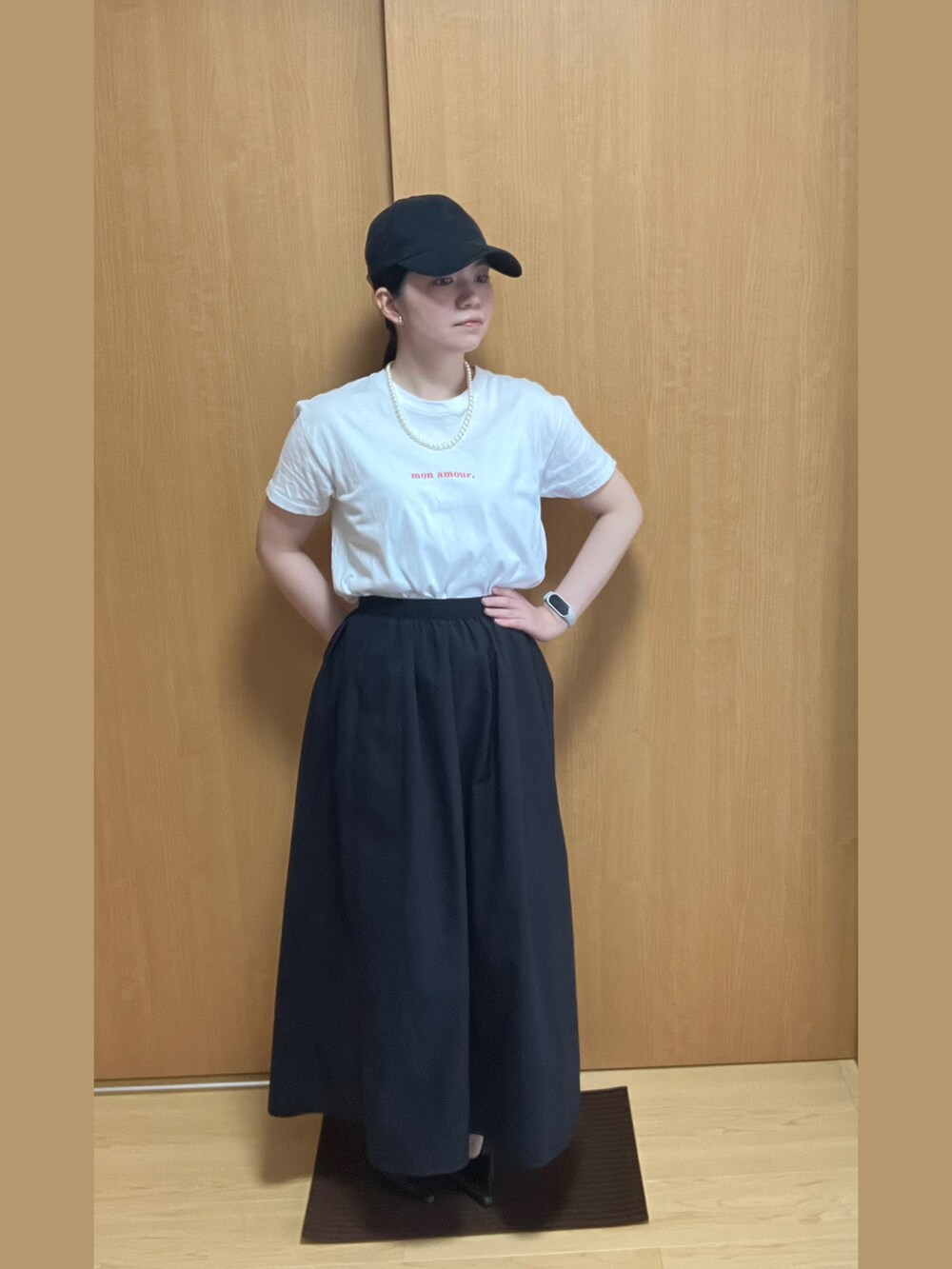 ホワイト系のTシャツ/カットソー、ブラック系のスカート、ブラック系のパンプスを着用したレディースの夏コーディネートの3枚目の写真