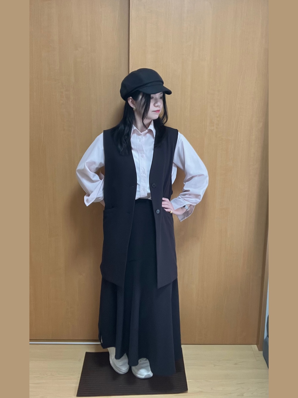 ピンク系のシャツ/ブラウス、ブラック系のスカート、ホワイト系のスニーカーを着用したレディースの春コーディネートの2枚目の写真