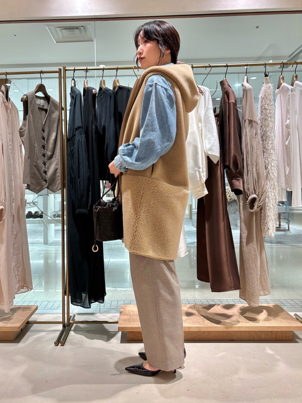 ブラウン系のその他パンツ、ベージュ系のベスト、ブルー系のシャツ/ブラウスを着用したレディースの夏コーディネートの2枚目の写真