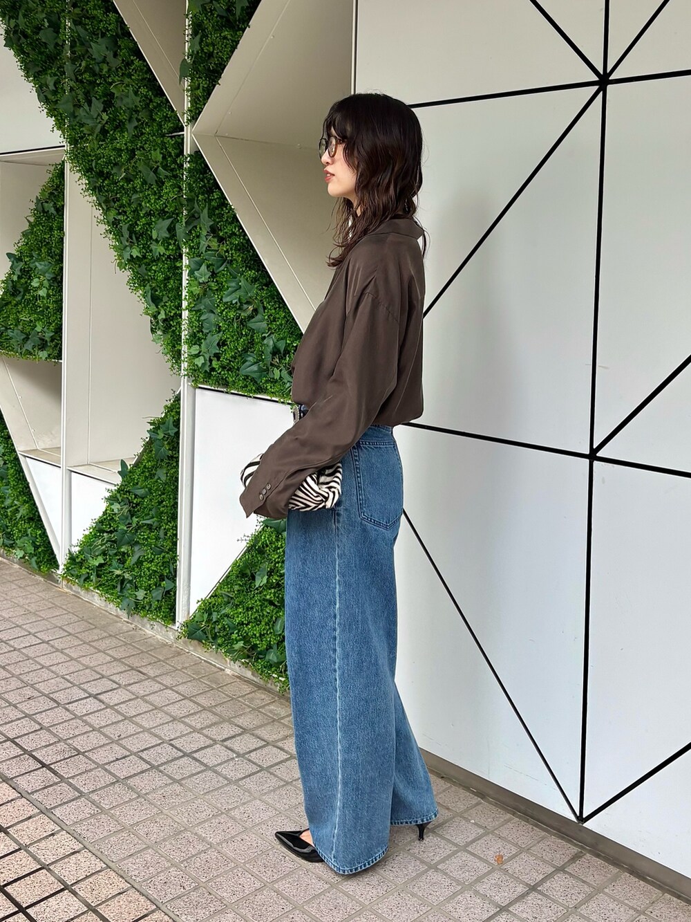 ブラウン系のシャツ/ブラウス、ブラック系のベルトを着用したレディースの夏コーディネートの2枚目の写真