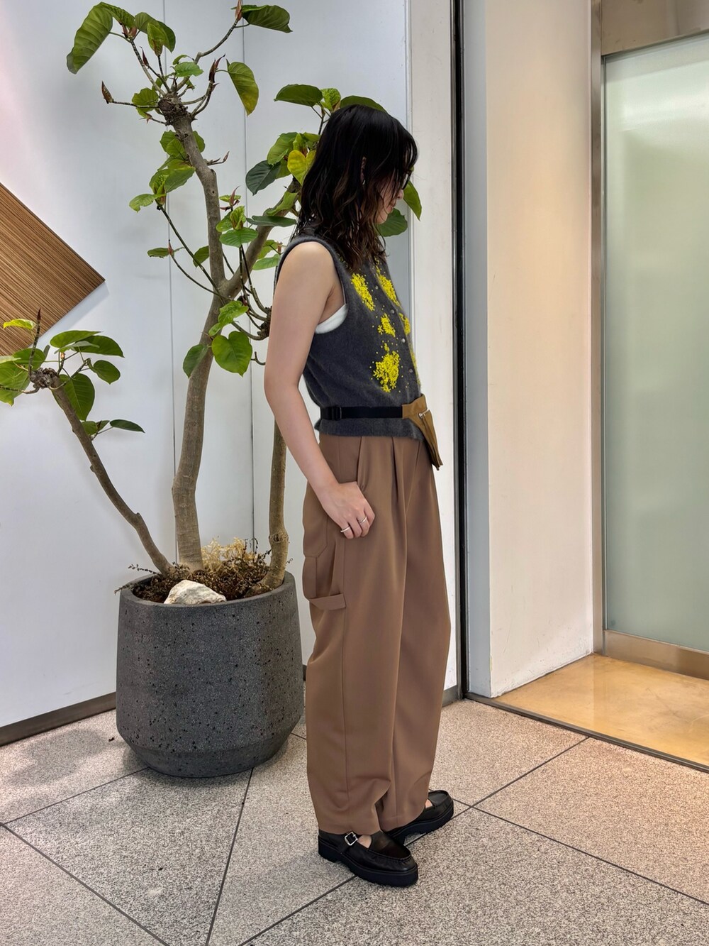 グレー系のベスト、イエロー系のボディバッグ/ウエストポーチ、ブラック系のローファーを着用したレディースの夏コーディネートの3枚目の写真