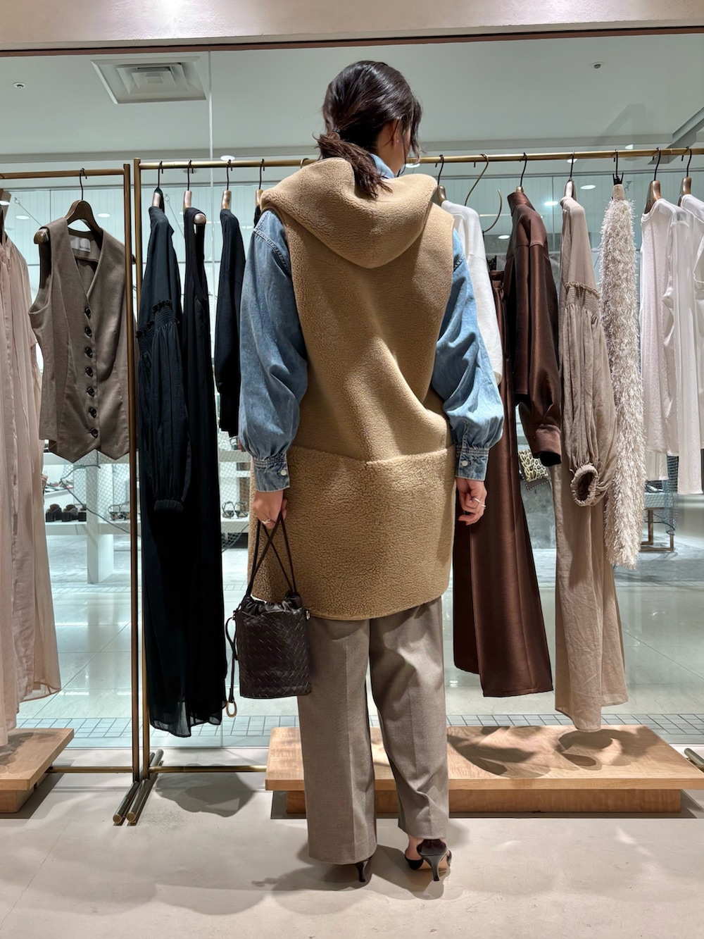 ブラウン系のその他パンツ、ベージュ系のベスト、ブルー系のシャツ/ブラウスを着用したレディースの夏コーディネートの3枚目の写真