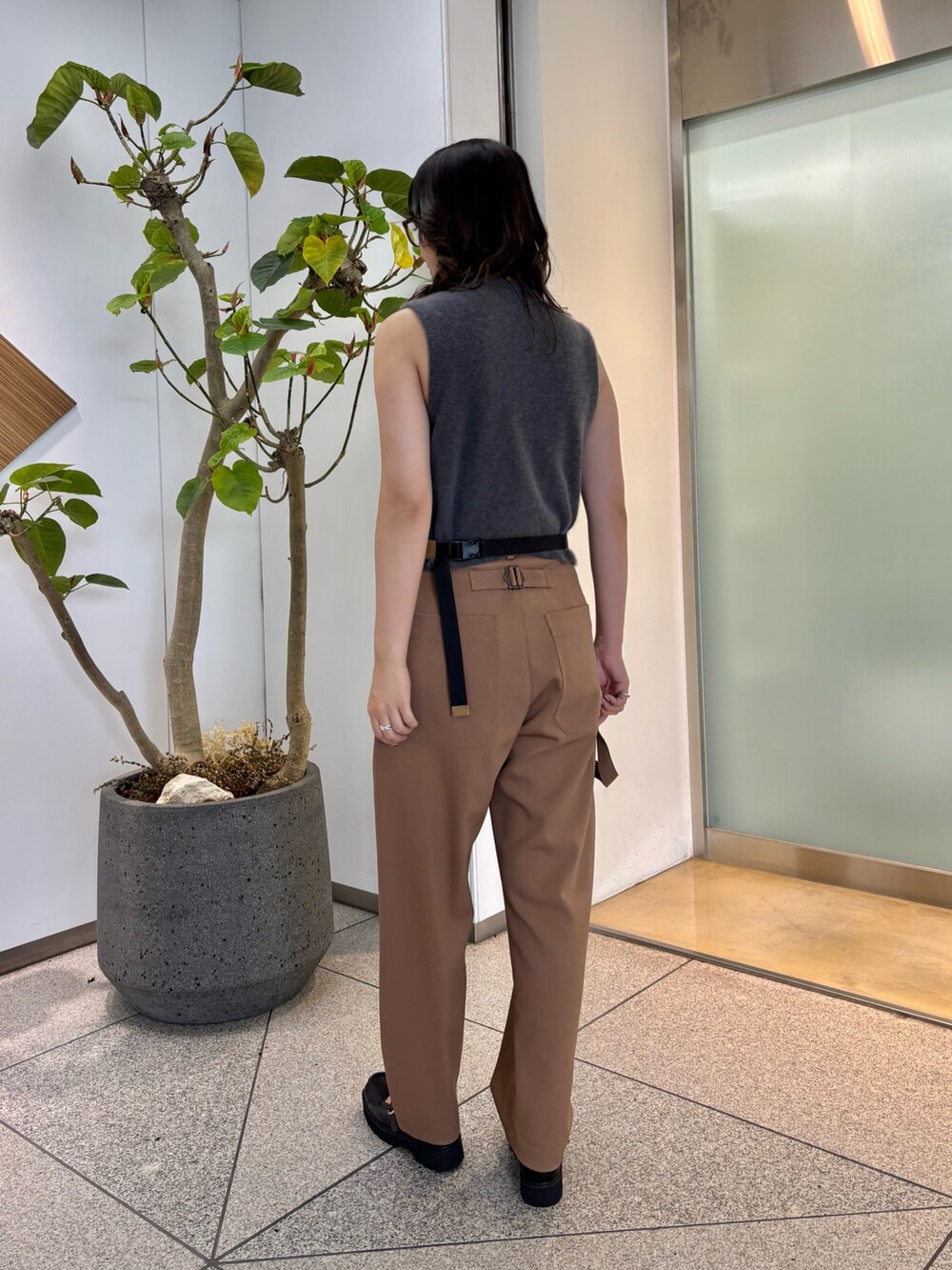 グレー系のベスト、イエロー系のボディバッグ/ウエストポーチ、ブラック系のローファーを着用したレディースの夏コーディネートの2枚目の写真