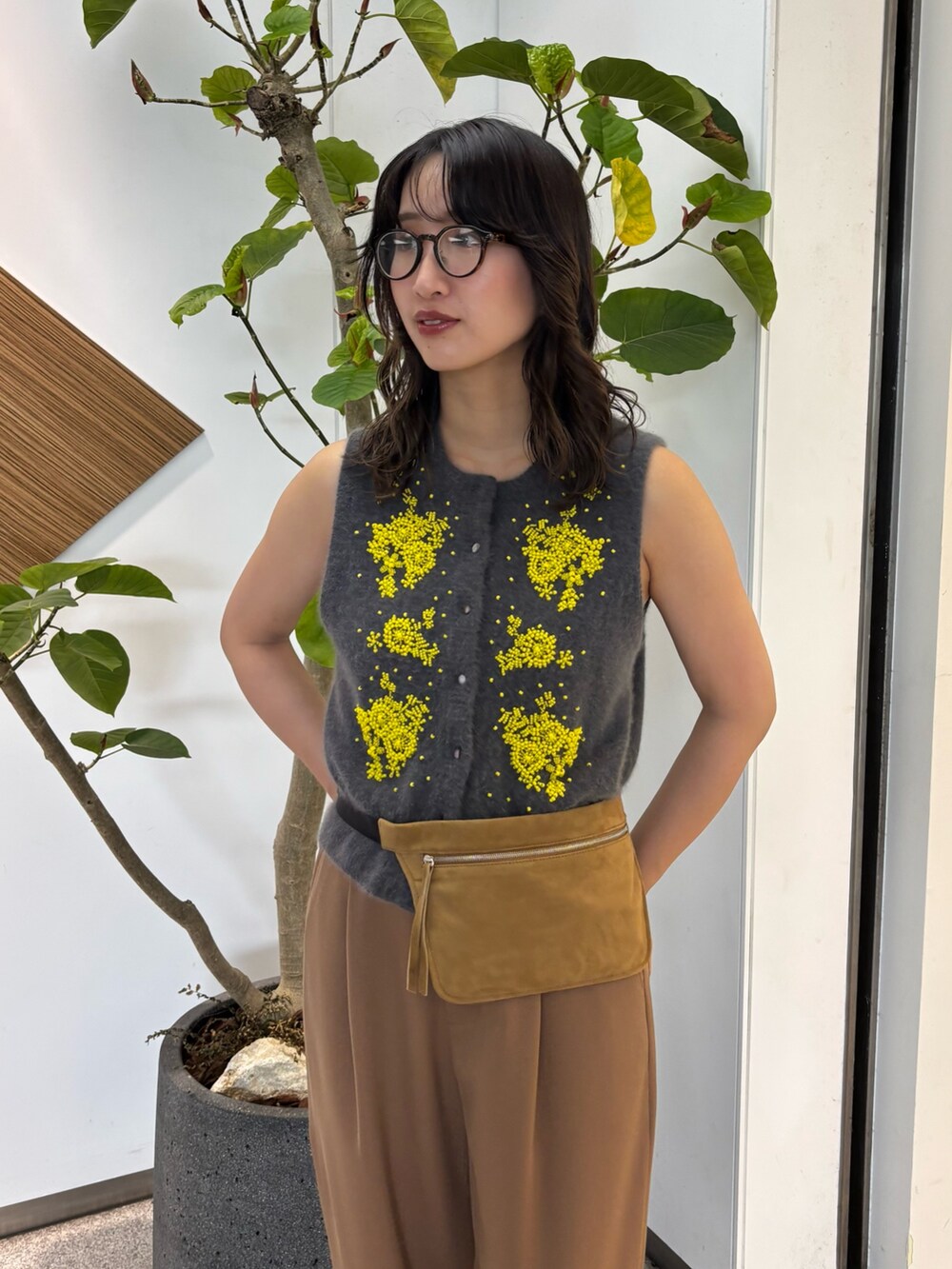 グレー系のベスト、イエロー系のボディバッグ/ウエストポーチ、ブラック系のローファーを着用したレディースの夏コーディネートの4枚目の写真