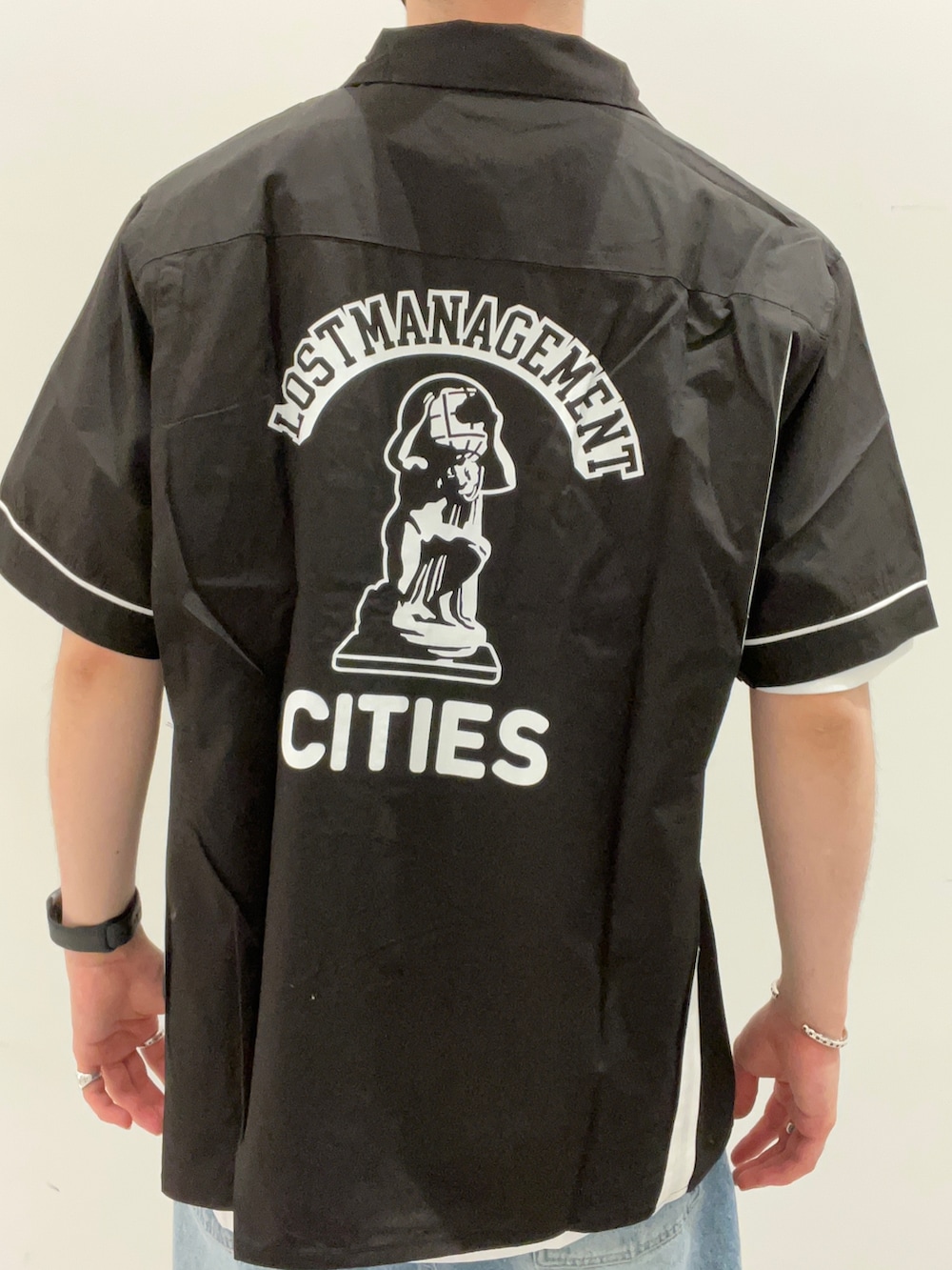 ブラック系のTシャツ/カットソー、ホワイト系のTシャツ/カットソー、ブルー系のデニムパンツを着用したメンズの夏コーディネートの3枚目の写真