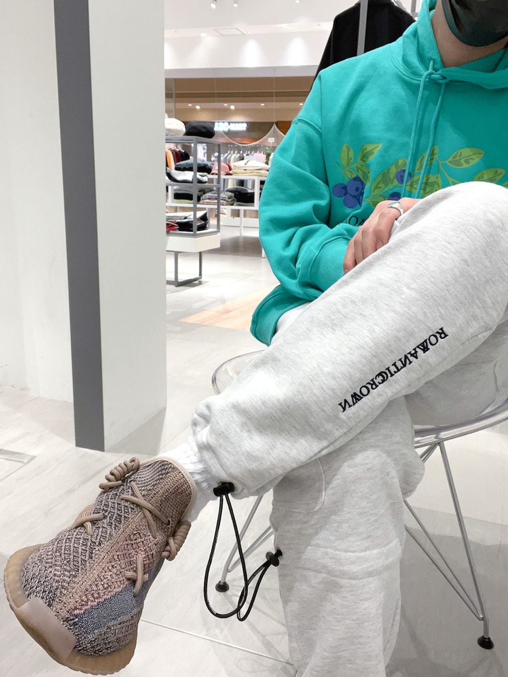 グリーン系のパーカー、グレー系のスウェットパンツ、ブラウン系のシューズを着用したメンズの春コーディネートの3枚目の写真