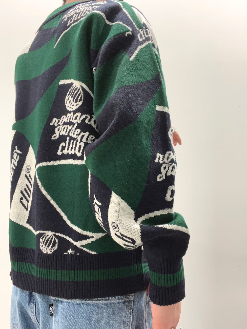 グリーン系のカーディガン/ボレロ、ブルー系のデニムパンツ、ホワイト系のスニーカーを着用したメンズの春コーディネートの3枚目の写真