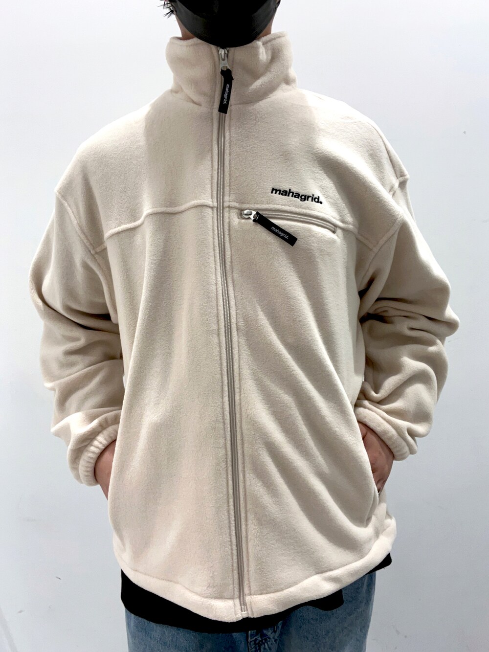 ブラック系のTシャツ/カットソー、ホワイト系のブルゾン、ブルー系のデニムパンツを着用したメンズの秋コーディネートの3枚目の写真