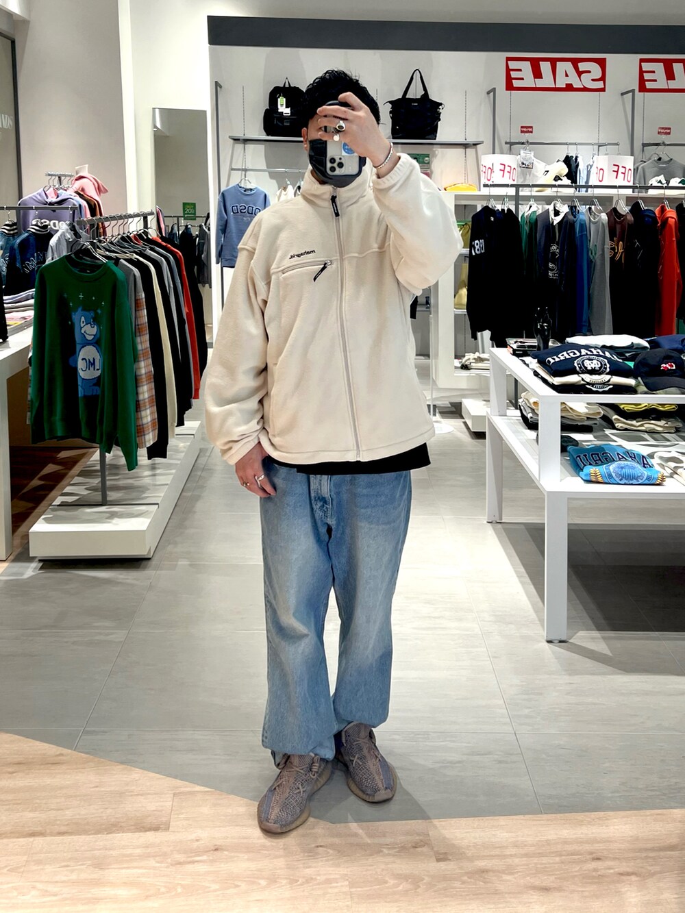 ブラック系のTシャツ/カットソー、ホワイト系のブルゾン、ブルー系のデニムパンツを着用したメンズの秋コーディネートの4枚目の写真