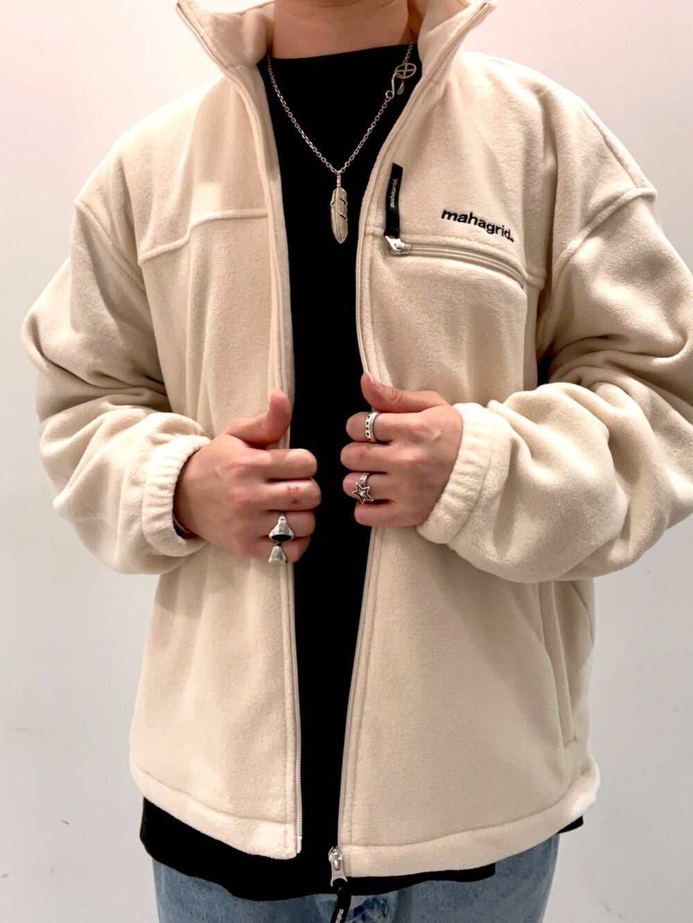 ブラック系のTシャツ/カットソー、ホワイト系のブルゾン、ブルー系のデニムパンツを着用したメンズの秋コーディネートの2枚目の写真