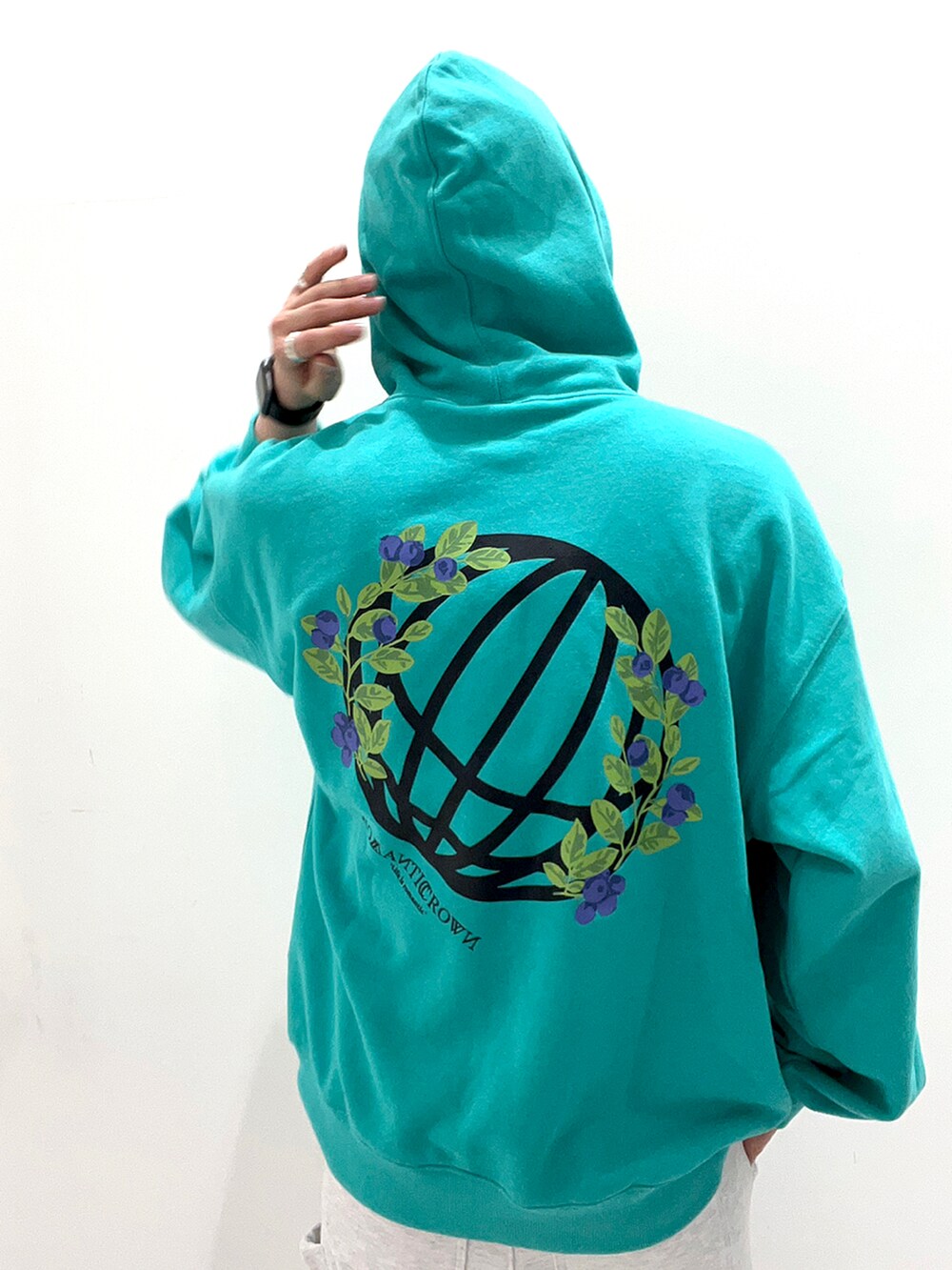 グリーン系のパーカー、グレー系のスウェットパンツ、ブラウン系のシューズを着用したメンズの春コーディネートの2枚目の写真