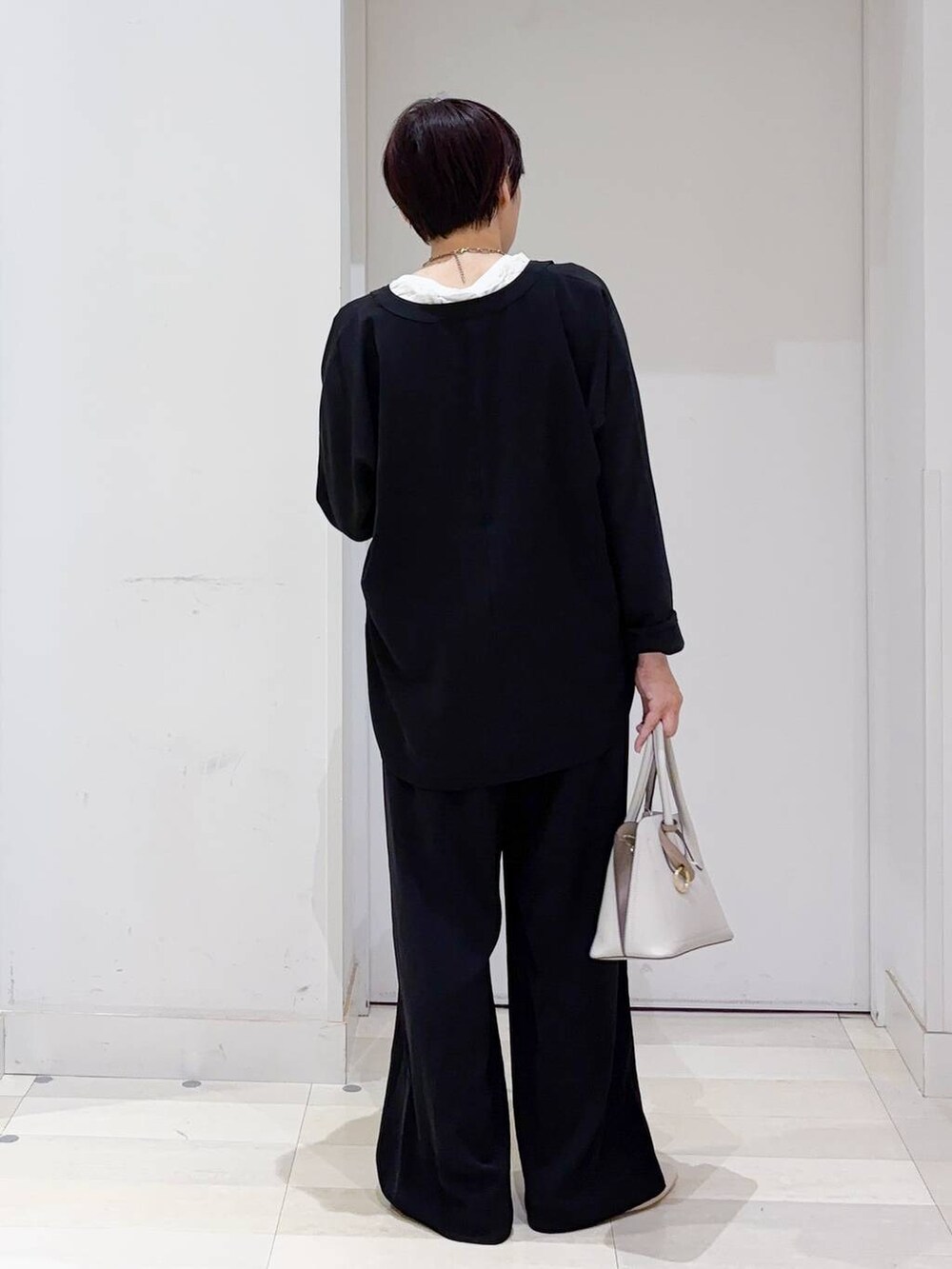 ベージュ系のパンプス、ホワイト系のショルダーバッグ、ブラック系のその他パンツを着用したレディースの秋コーディネートの4枚目の写真
