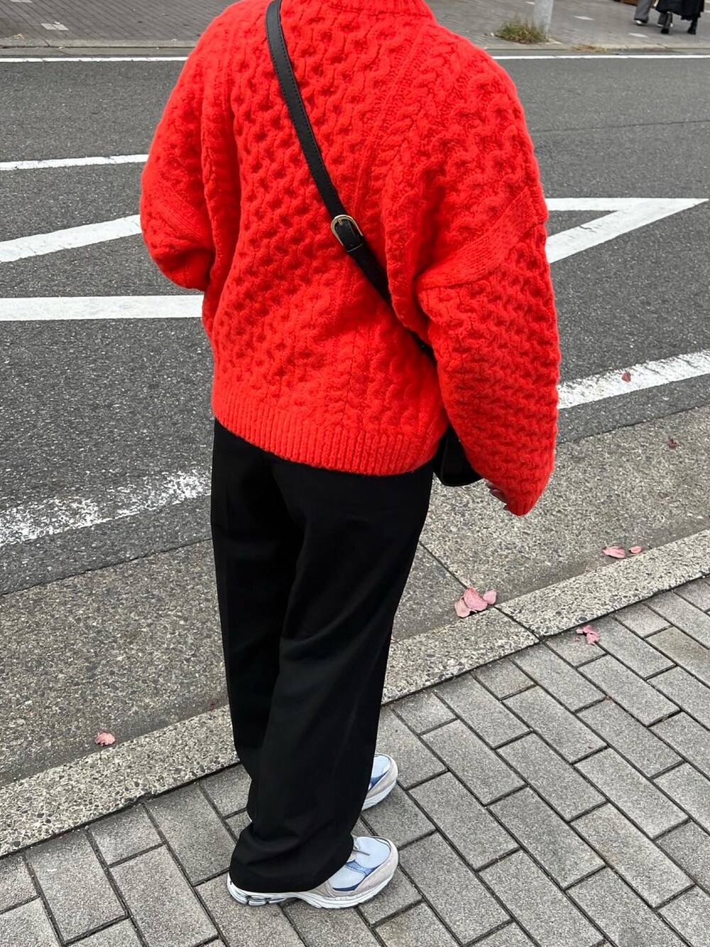 ブラック系のパンツ、グレー系のスニーカー、ブラック系のショルダーバッグを着用したレディースの秋コーディネートの4枚目の写真