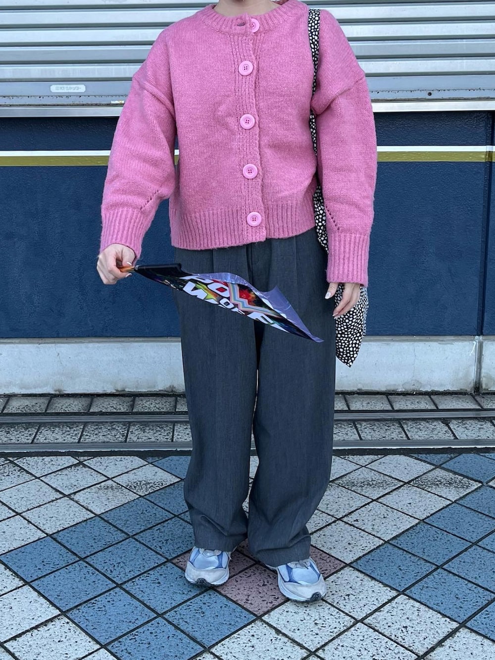 グレー系のスラックス、ピンク系のカーディガン/ボレロ、グレー系のスニーカーを着用したレディースの冬コーディネートの3枚目の写真