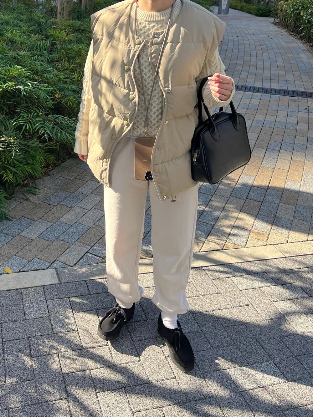 ホワイト系のスウェットパンツ、ブラック系のブーツ、ホワイト系のニット/セーターを着用したレディースの冬コーディネートの4枚目の写真