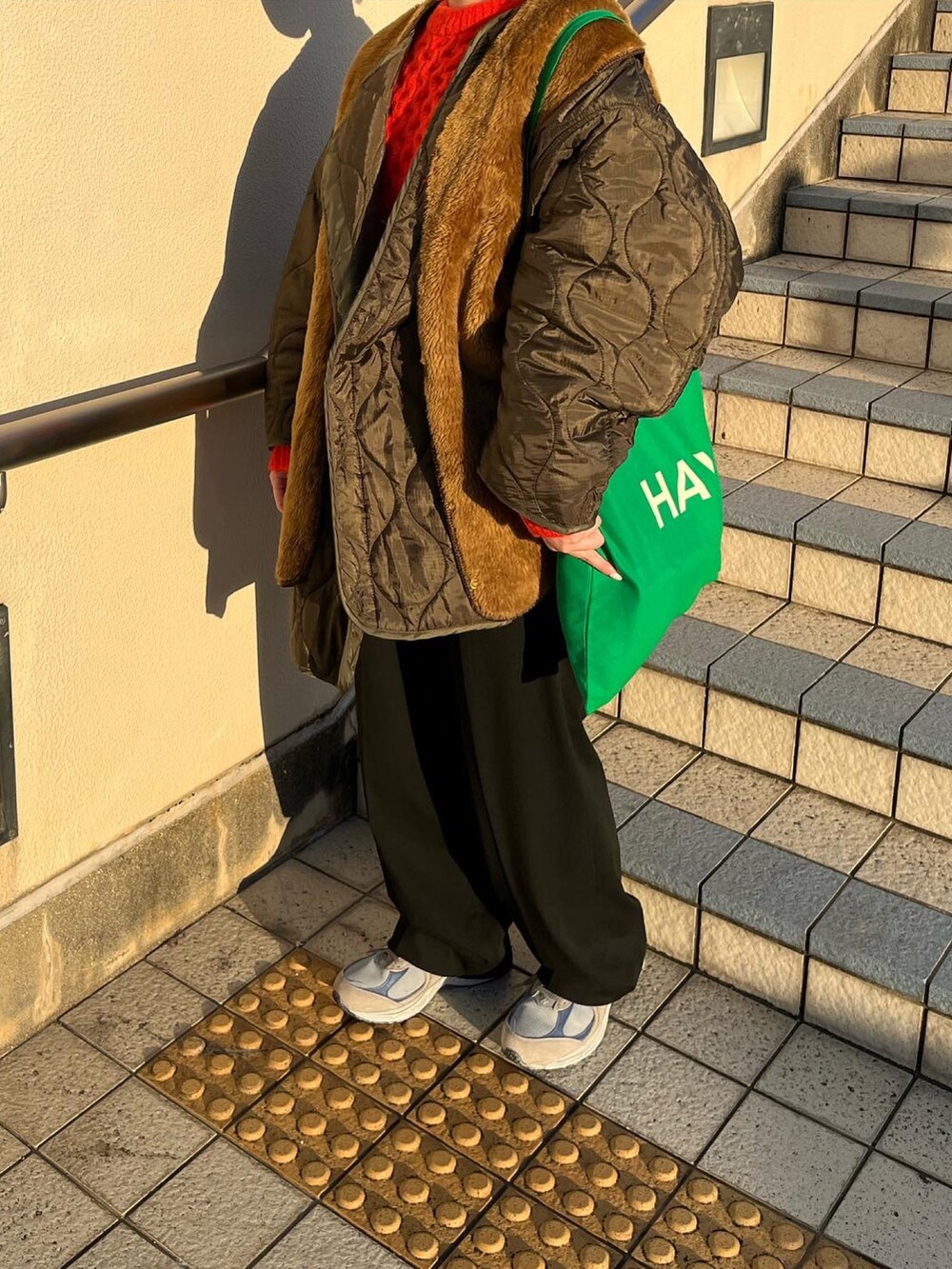 ブラック系のパンツ、グリーン系のモッズコート、ブラウン系のベストを着用したレディースの冬コーディネートの2枚目の写真