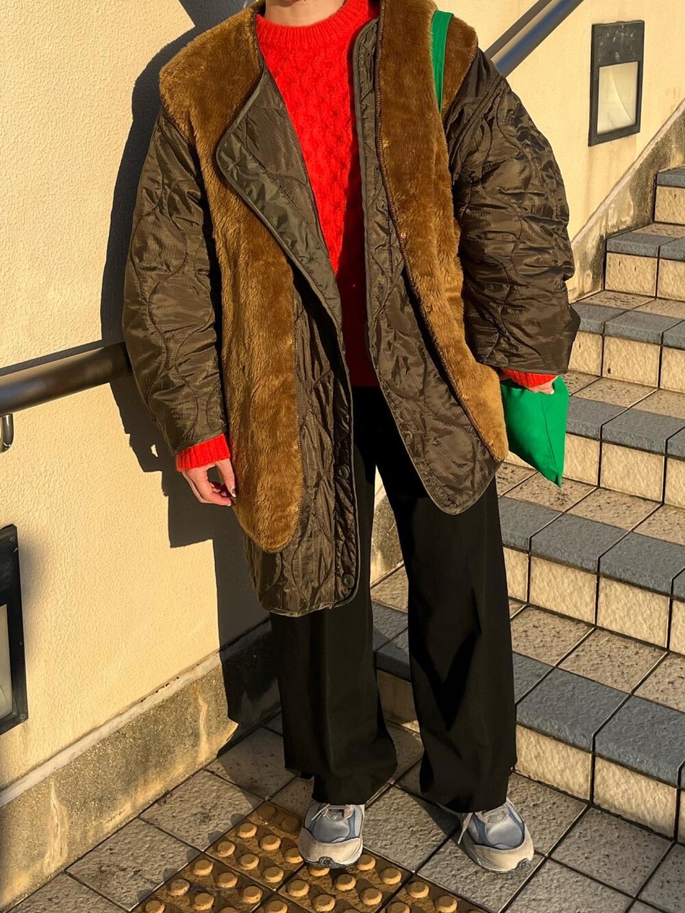 ブラック系のパンツ、グリーン系のモッズコート、ブラウン系のベストを着用したレディースの冬コーディネートの3枚目の写真