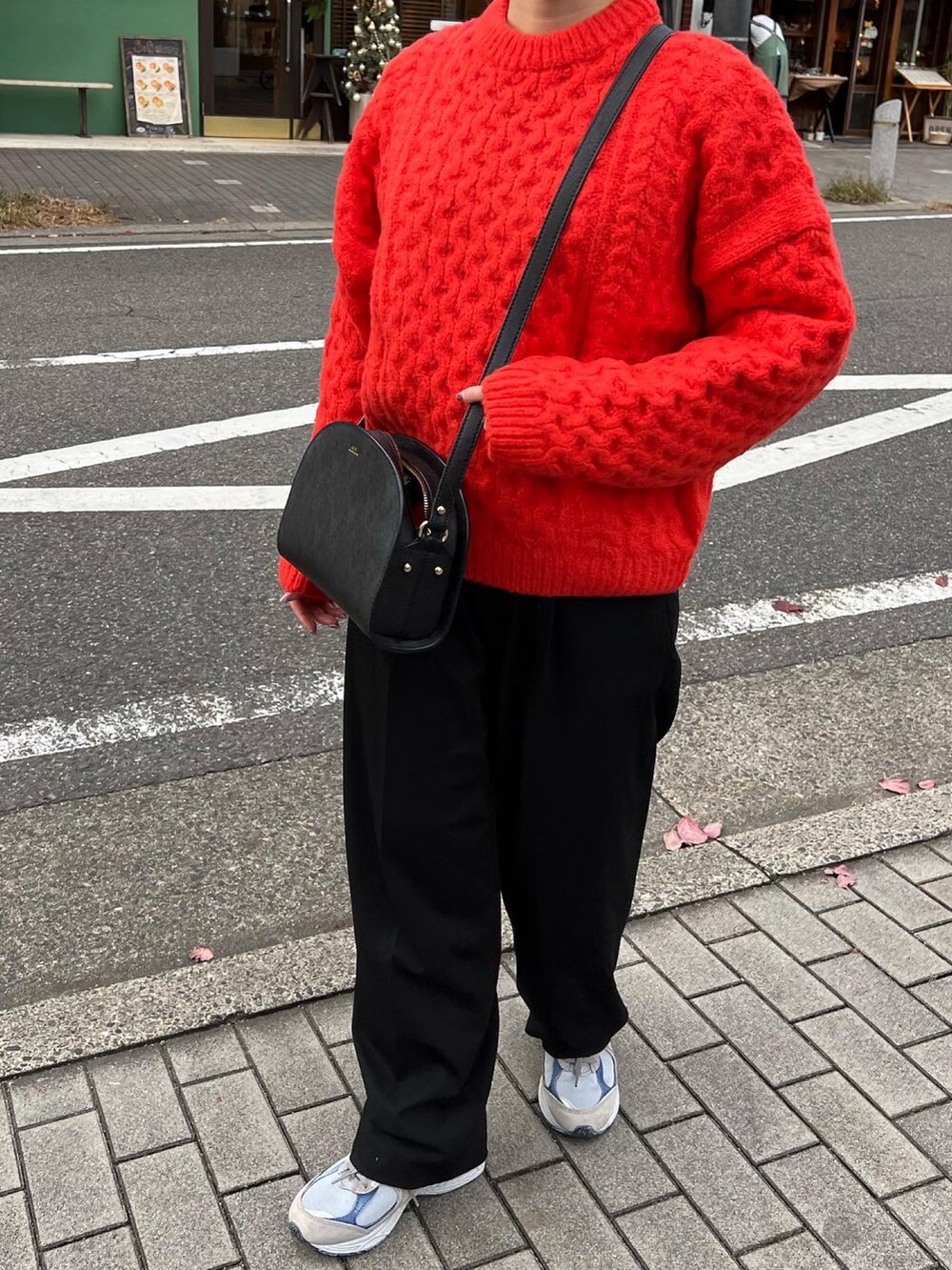 ブラック系のパンツ、グレー系のスニーカー、ブラック系のショルダーバッグを着用したレディースの秋コーディネートの3枚目の写真