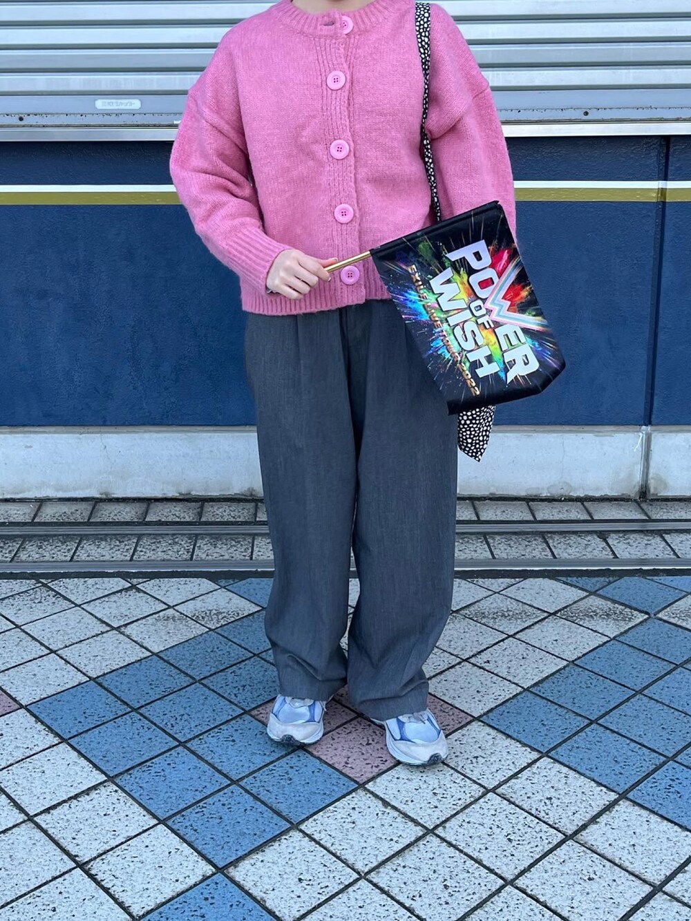 グレー系のスラックス、ピンク系のカーディガン/ボレロ、グレー系のスニーカーを着用したレディースの冬コーディネートの2枚目の写真