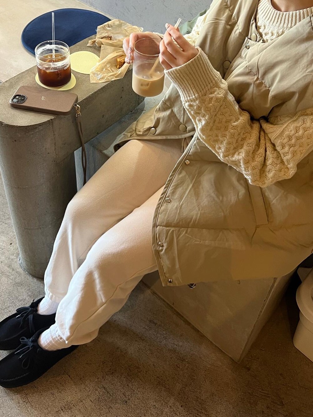 ホワイト系のスウェットパンツ、ブラック系のブーツ、ホワイト系のニット/セーターを着用したレディースの冬コーディネートの5枚目の写真