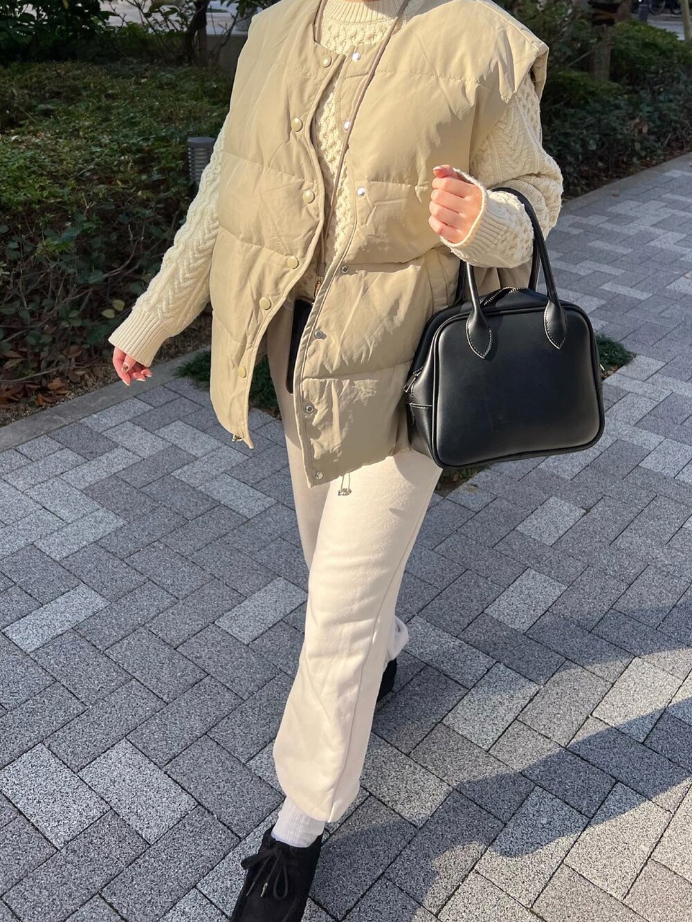 ホワイト系のスウェットパンツ、ブラック系のブーツ、ホワイト系のニット/セーターを着用したレディースの冬コーディネートの3枚目の写真