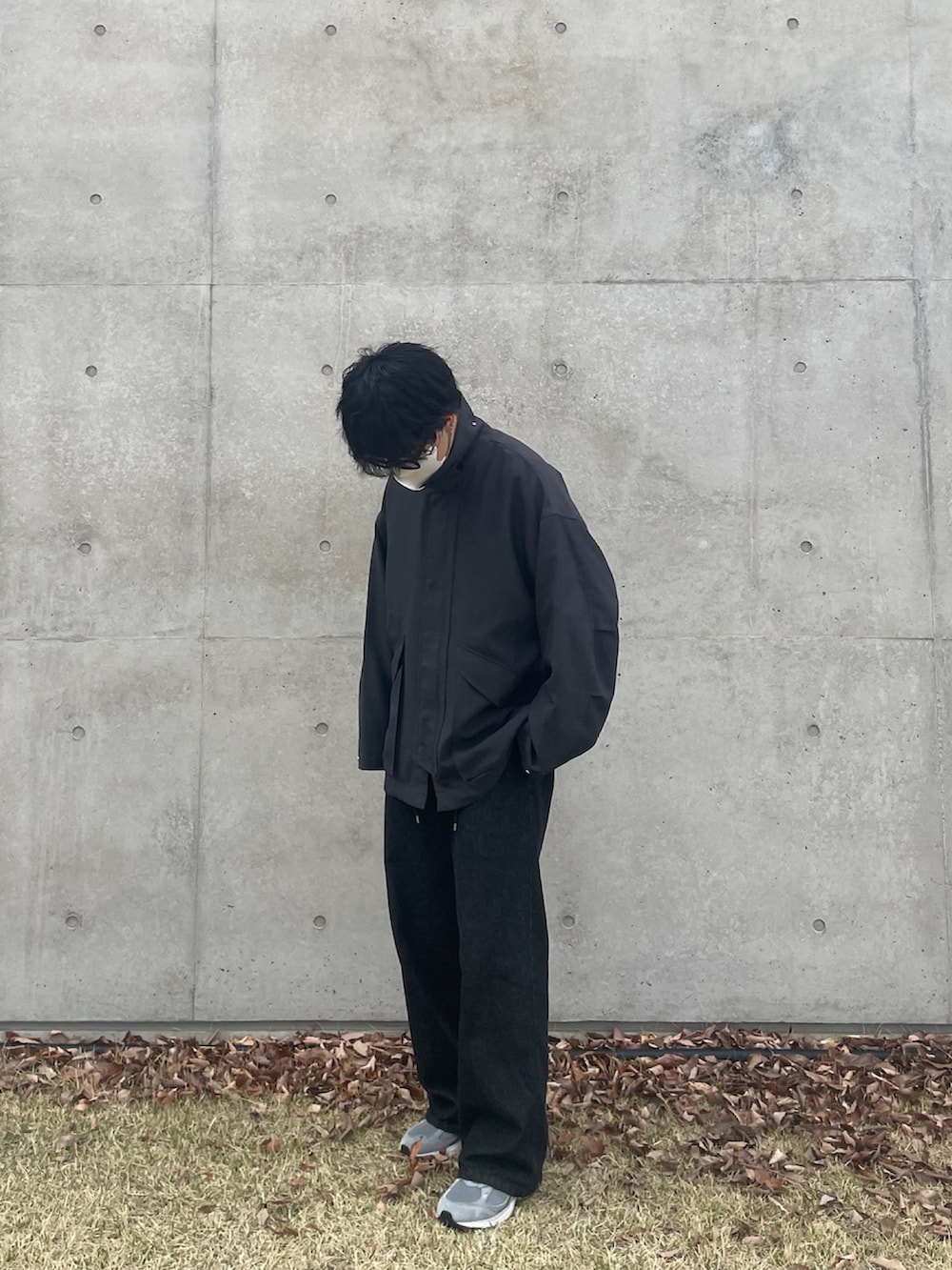 グレー系のブルゾン、ブラック系のデニムパンツ、グレー系のスニーカーを着用したメンズの春コーディネートの2枚目の写真