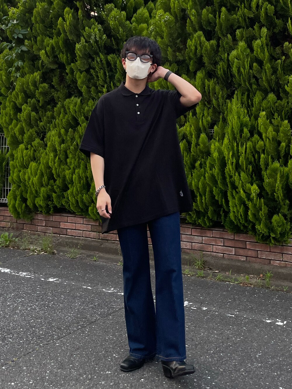 ブラック系のポロシャツ、ブルー系のデニムパンツ、ブラック系のブーツを着用したメンズの夏コーディネートの2枚目の写真