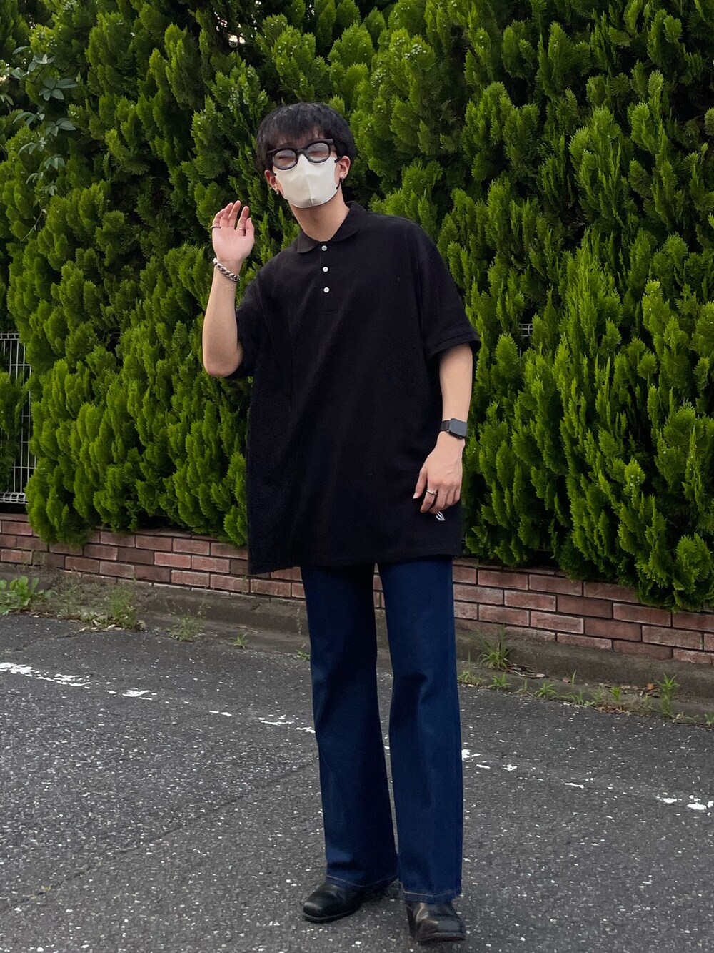 ブラック系のポロシャツ、ブルー系のデニムパンツ、ブラック系のブーツを着用したメンズの夏コーディネートの3枚目の写真