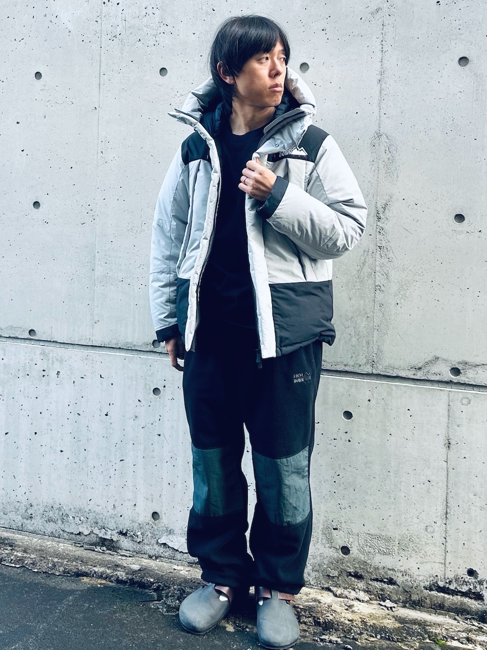 グレー系のダウンジャケット/コート、ブラウン系のスリッポン、ブラック系のその他パンツを着用したメンズの冬コーディネートの3枚目の写真