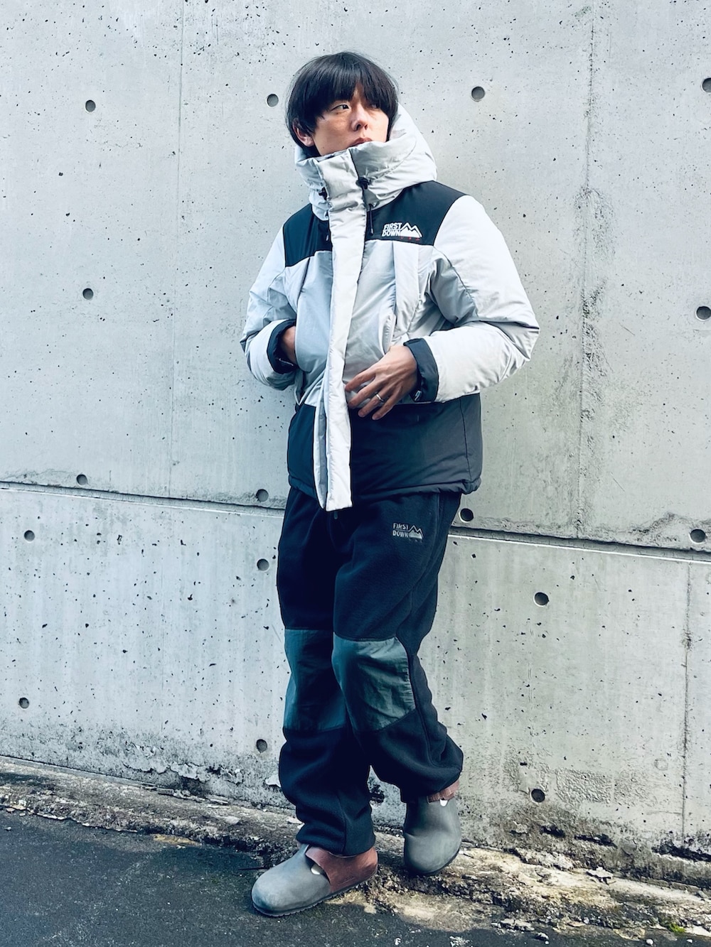 グレー系のダウンジャケット/コート、ブラウン系のスリッポン、ブラック系のその他パンツを着用したメンズの冬コーディネートの6枚目の写真