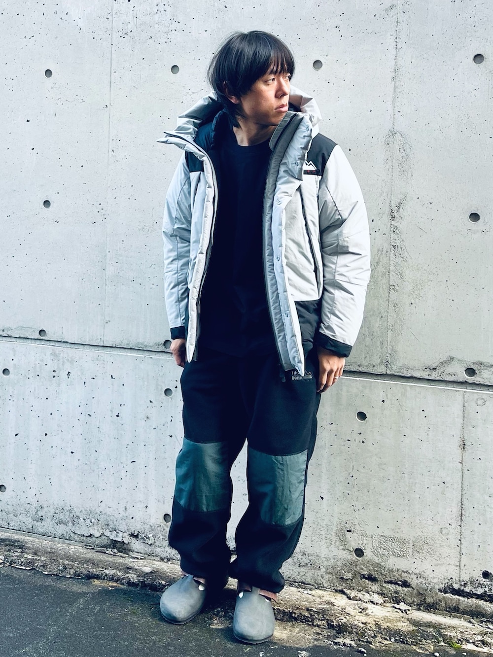 グレー系のダウンジャケット/コート、ブラウン系のスリッポン、ブラック系のその他パンツを着用したメンズの冬コーディネートの4枚目の写真