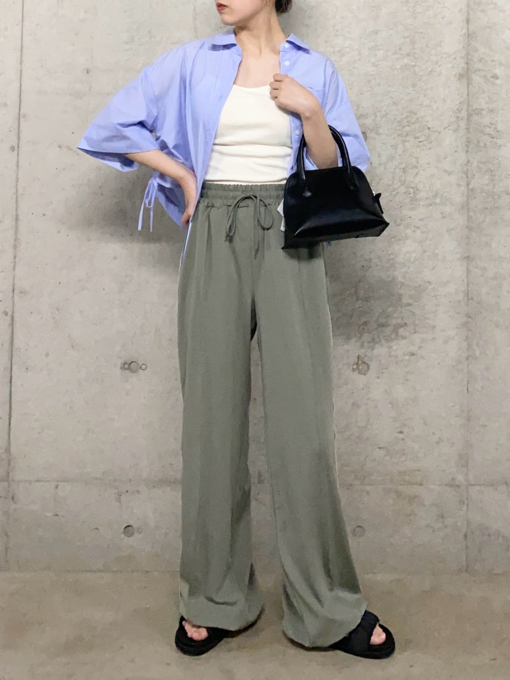 グリーン系のその他パンツ、ブラック系のサンダル、ホワイト系のキャミソールを着用したレディースの夏コーディネートの2枚目の写真