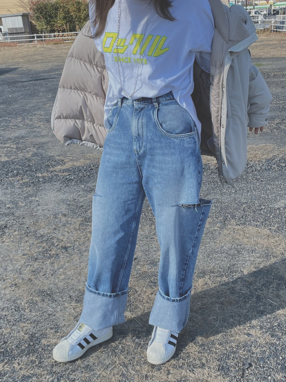 ブルー系のデニムパンツ、ホワイト系のTシャツ/カットソー、ホワイト系のスニーカーを着用したレディースの冬コーディネートの3枚目の写真