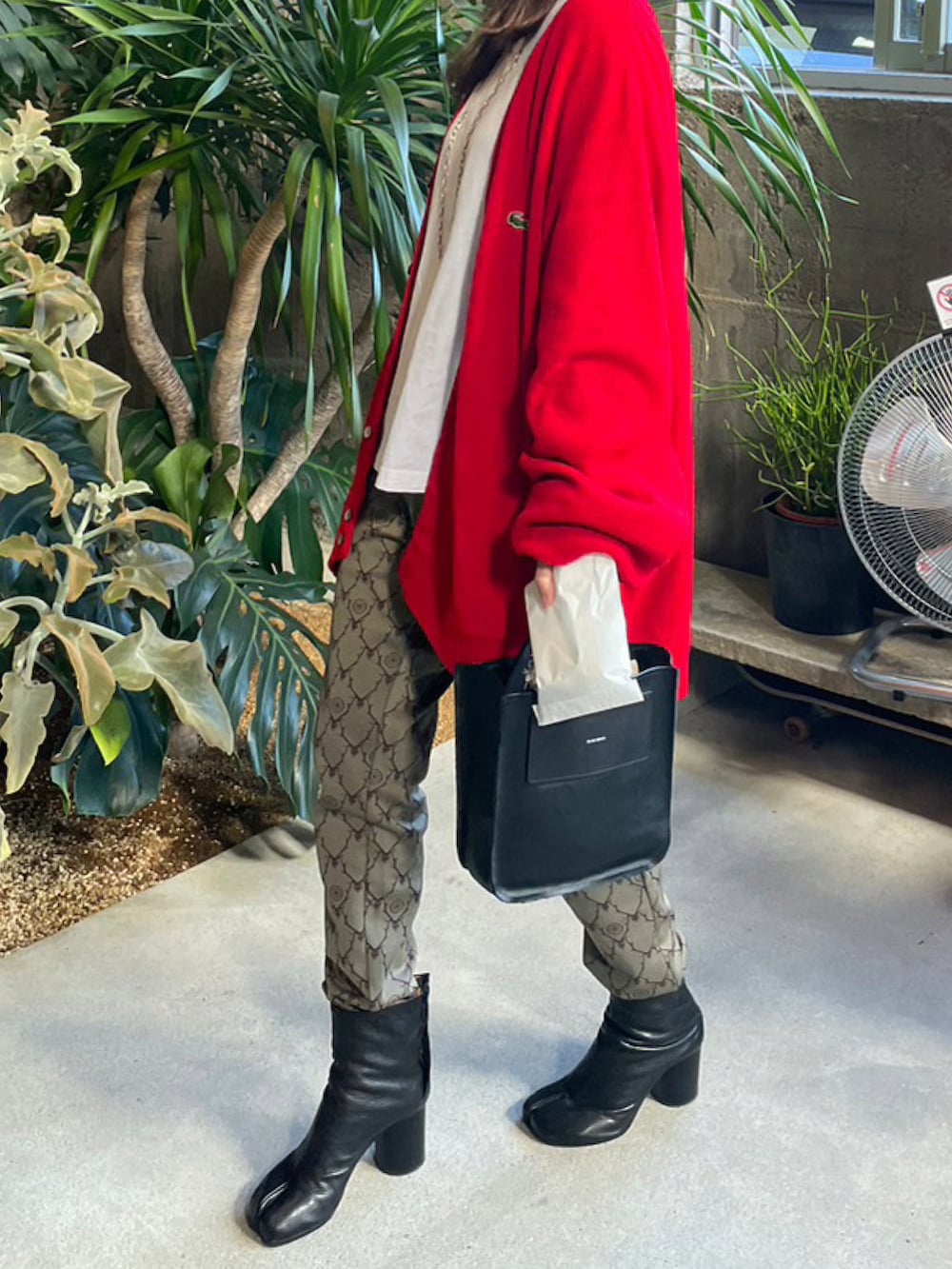 レッド系のカーディガン/ボレロ、その他のパンツ、ブラック系のブーツを着用したレディースの冬コーディネートの2枚目の写真